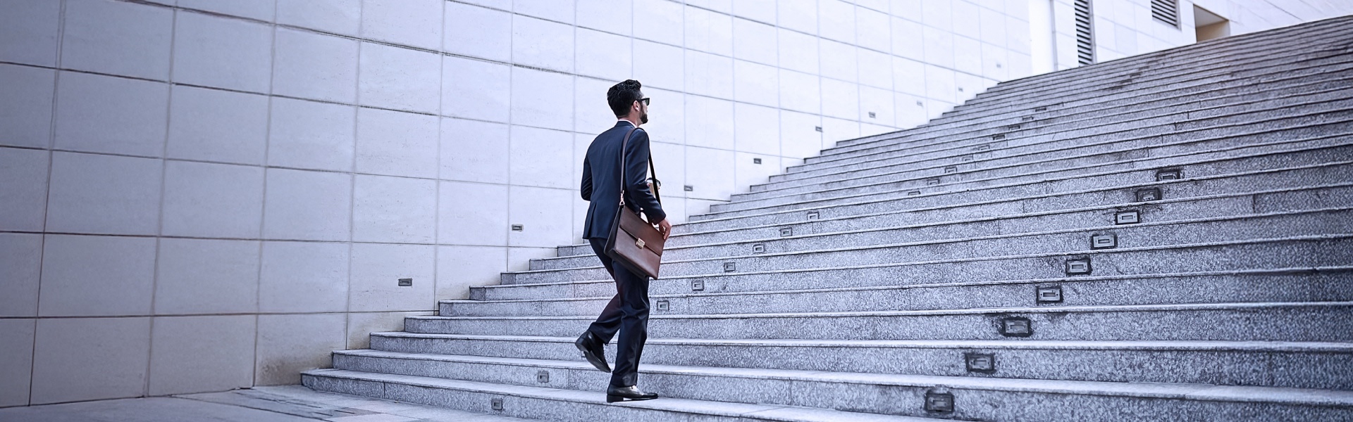 Mann der im business outfit eine Treppe hoch läuft
